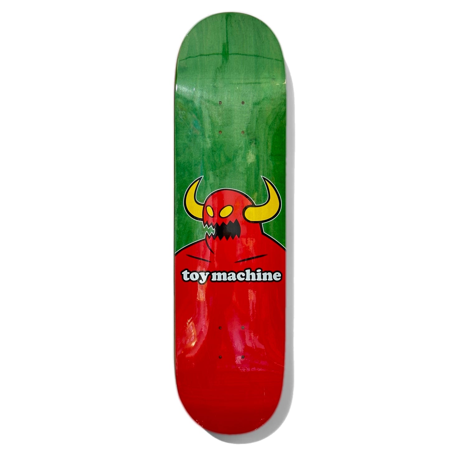 Toy Machine Team Monster Skateboard Deck; skateboard deck with green background and illustrated graphic featuring horned red monster (classic Toy Machine Monster character); white lettering spells out “toy machine” 