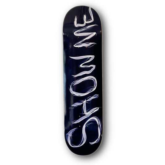 Show Me SmokeSkateboard Deck; skateboard deck features black background illustrated graphic of white lettering that spells out “Show Me” in font that looks like smoke